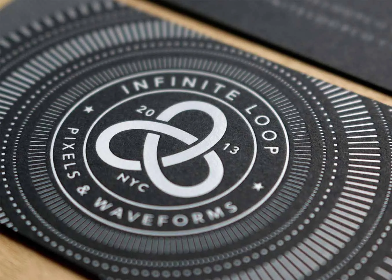 White foil stamped business card on black paper — front view